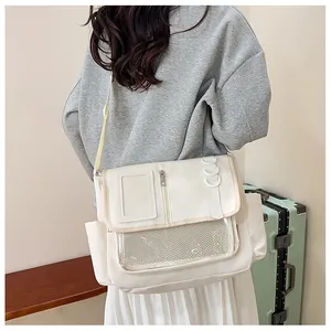 Détail d'un grand sac bandoulière ivoire avec poches transparentes et sangle réglable