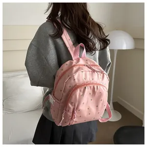 Close-up of pink floral backpack made of waterproof nylon fabric with secure zippers