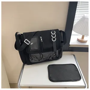 Détail d'un sac messager en toile noire avec fenêtre transparente en PVC pour badges