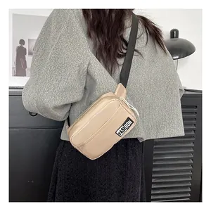 Detailed view of champagne gold crossbody chest bag with adjustable black strap on a model