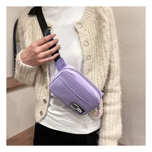 Detail of purple nylon waist bag featuring a front zipper and Fashion logo on adjustable strap