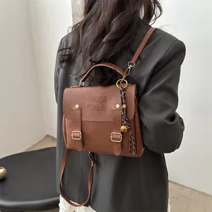 Vintage-Rucksack aus braunem Leder mit Doppel-Dornschnalle und gewebtem Glockenanhänger
