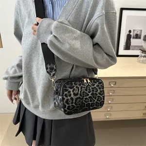 Fashionable leopard print crossbody camera bag with wide strap and gold hardware