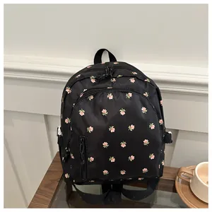 Close-up of black nylon backpack featuring delicate pink floral print and zipper details