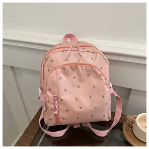 Detailed close-up of a pink floral student backpack with functional front pocket