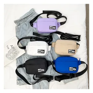 Group display of five colorful nylon crossbody waist bags on denim fabric background