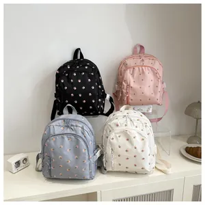 Detailed arrangement of four floral mini backpacks in black, pink, blue, and cream colors