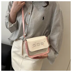 Detail of white and pink frosted crossbody bag featuring cute cartoon animals and leather strap