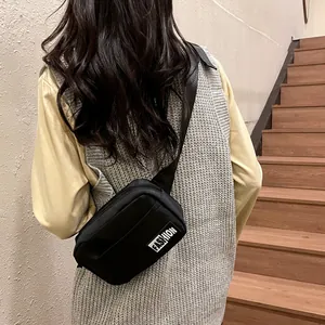 Black minimalist waterproof chest bag with fashion label shown on model back view