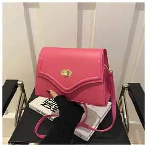 Dettaglio della borsa a tracolla in pelle PU rosso rosa con chiusura rotante ovale dorata