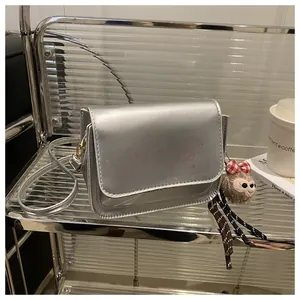 Detail of silver metallic crossbody bag with cartoon print and plush bear charm