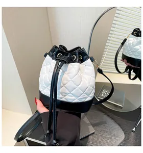 Detailed view of quilted leather bucket bag with contrast trim and gold metal hardware