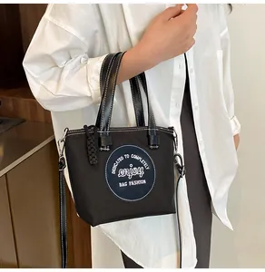 Détails des surpiqûres blanches sur le sac seau noir en nylon avec patch décoratif