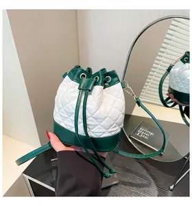 Close-up of quilted leather bucket bag with green trim and adjustable drawstring closure