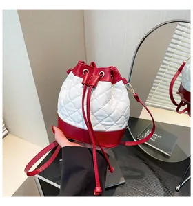 Detailed macro view of quilted red and white contrast stitching bucket bag with drawstring