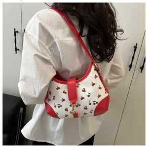 Rear view of model wearing white cherry print shoulder bag with red leather trim