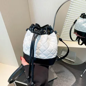 Chic quilted drawstring bucket bag with black and white color block and gold hardware