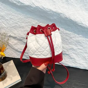 Quilted drawstring bucket bag in red and white contrast faux leather with long strap