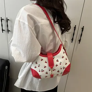 White shoulder bag with red cherry print and PU leather trim shown on a model