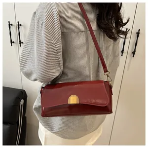 Vue détaillée du sac à bandoulière rectangulaire rouge foncé avec boucle dorée