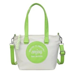 Sac seau bicolore en nylon blanc cassé et vert avec bandoulière réglable pratique