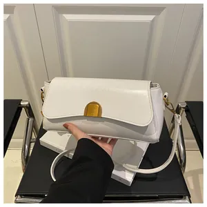 Détail du sac bandoulière blanc cassé avec boucle en métal doré et finition lisse