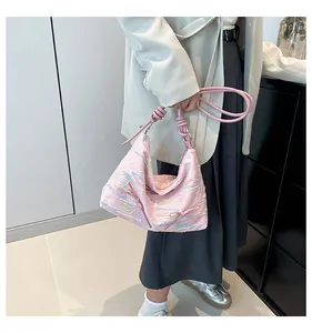 Détail du sac hobo rose avec broderie ondulée et bandoulière nouée élégante en gros plan
