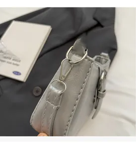 Detailed macro shot of silver lychee texture leather and metallic hardware on shoulder bag