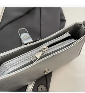 Detailed close-up of smooth metal zipper and textured gray leather interior pocket