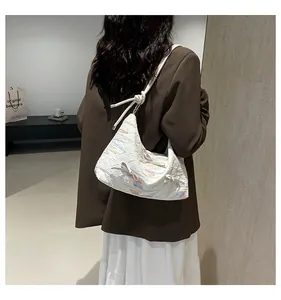 Vue détaillée d'un sac à bandoulière crème avec pampilles colorées et nœuds décoratifs