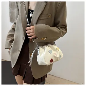 Détail du sac seau blanc cassé à cordon avec cœurs en cuir colorés et chaîne argentée