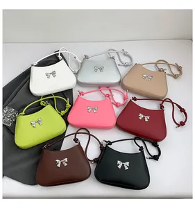 Présentation à plat de sacs à bandoulière avec nœuds en huit couleurs dont blanc et argent