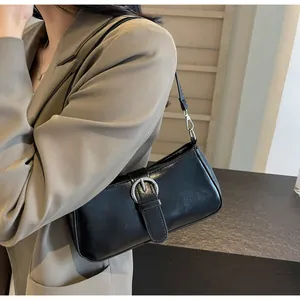 Close-up of black baguette underarm bag with silver buckle and smooth matte finish