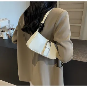 Detail of a creamy white PU leather shoulder bag with a silver buckle and textured finish