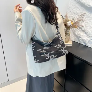 Sac à bandoulière noir tendance avec motif à vagues roses porté par un mannequin