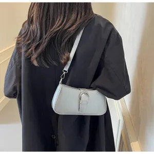 Back view of model wearing a light blue metallic baguette bag with silver buckle