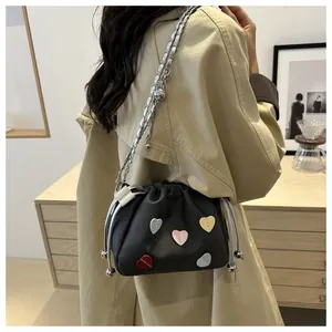 Détail du sac seau noir avec cœurs 3D colorés et bandoulière en chaîne argentée