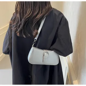Detail of silver gray leather shoulder bag showing the buckle strap and metallic finish