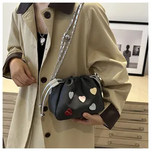 Détail du sac seau noir avec patchs de cœur colorés et bandoulière en chaîne argentée