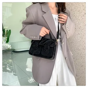 Details einer schwarzen Vintage-Samt-Umhängetasche mit Doppel-Schnalle und Griff