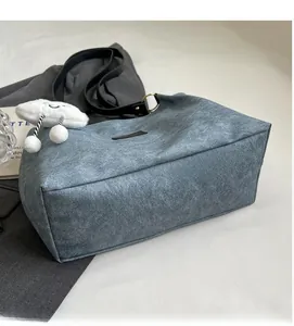 Detail of navy tote bag showing soft textured fabric and plush cloud charm accessory