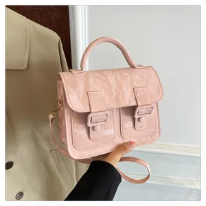 Detailansicht der hellrosa Cambridge-Tasche mit Textur und goldener Metallschnalle