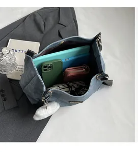 Blue denim hobo bag interior showing large capacity for tablet, phone, and accessories