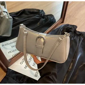 Detail of silver metallic baguette bag featuring a large silver buckle and slim shoulder strap