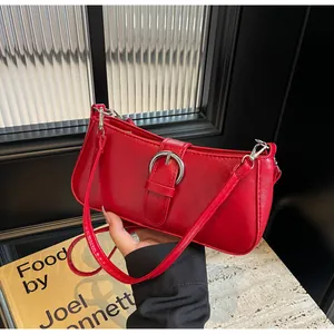 Detail of red leather underarm bag with silver ring buckle and detachable shoulder strap