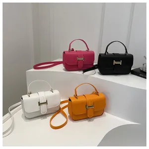 Detailed view of four colorful mini square bags with gold H buckles on a white pedestal