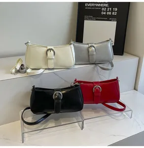 Detail showing mini shoulder bags in cream, silver, black, and red with metallic buckles