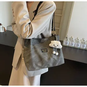 Detail of dark grey canvas tote bag with plush cloud charm and black shoulder straps