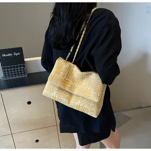 Close-up of yellow and white geometric jacquard pattern shoulder bag with gold chain strap
