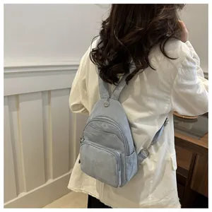 Detail of light blue waterproof nylon mini backpack with adjustable straps on model